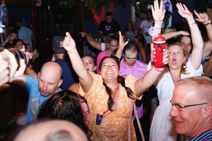 Group of people dancing energetically at a lively party.