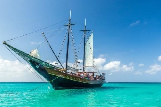 a blue and white boat sitting next to a body of water