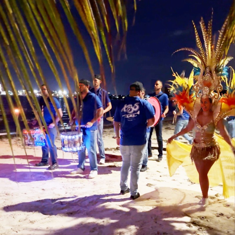 a group of people standing on top of a sandy beach