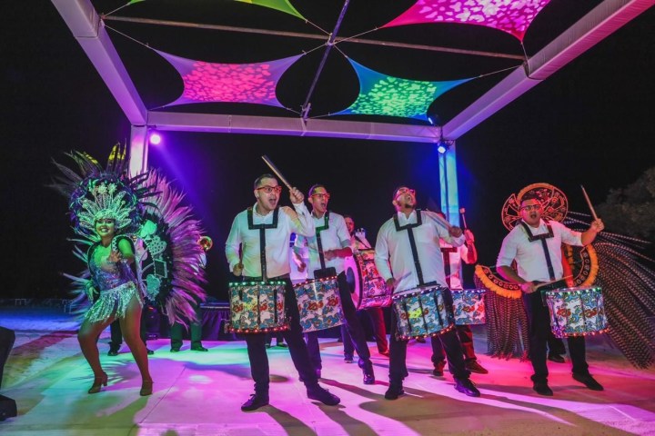 a group of people standing next to a christmas tree