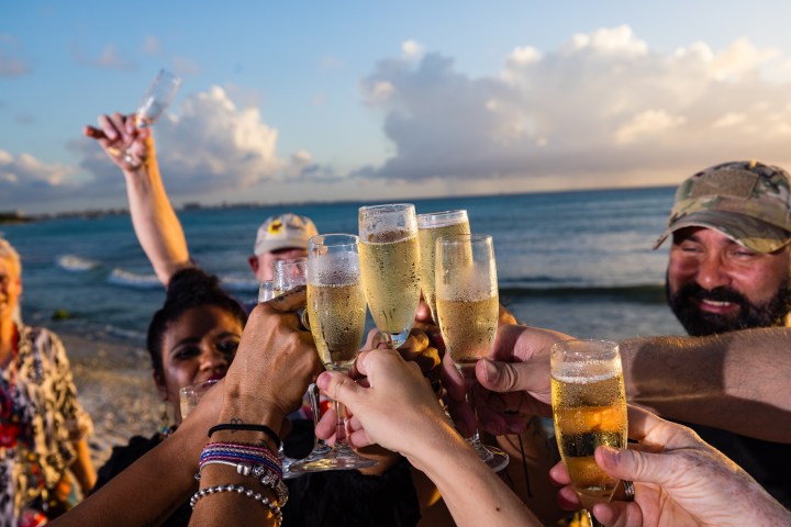 a group of people that are drinking water from a beach