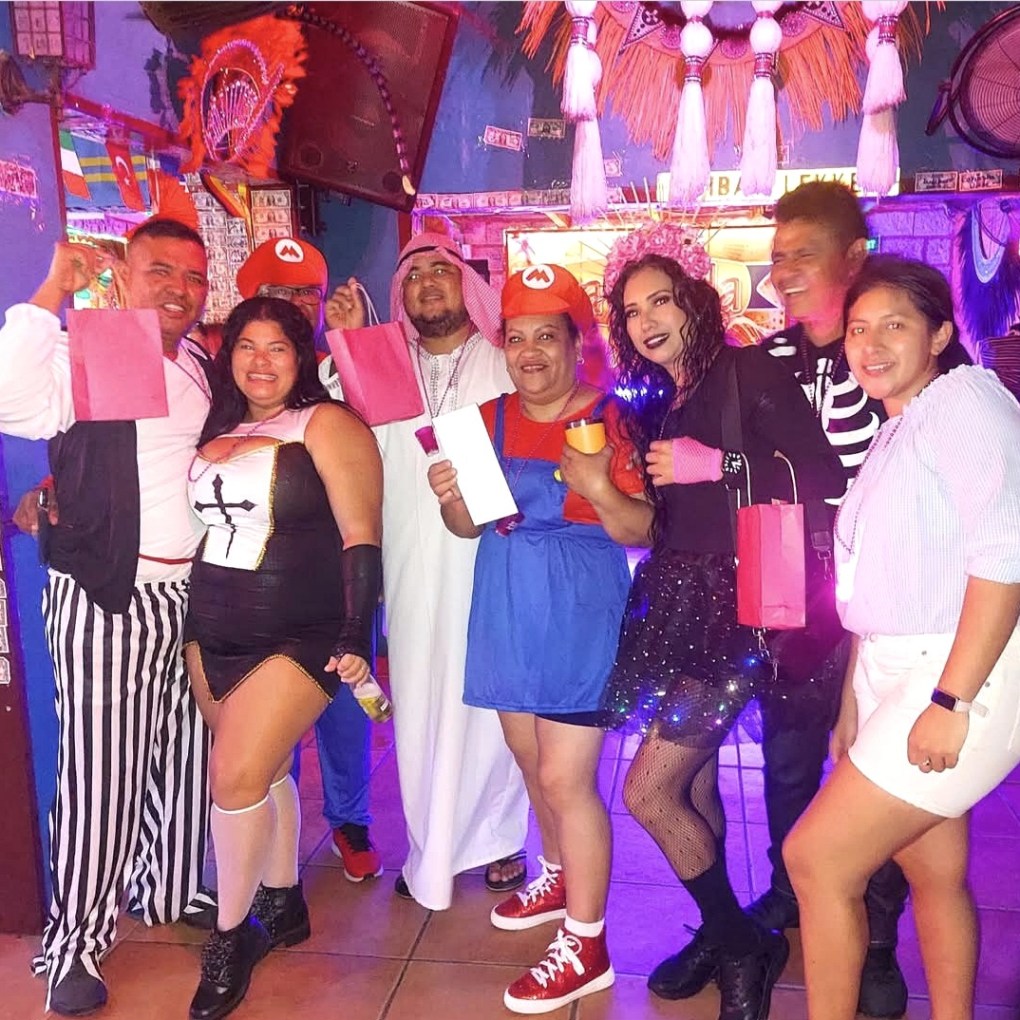 Guests in colorful Halloween costumes celebrating with Kukoo Kunuku in Aruba.